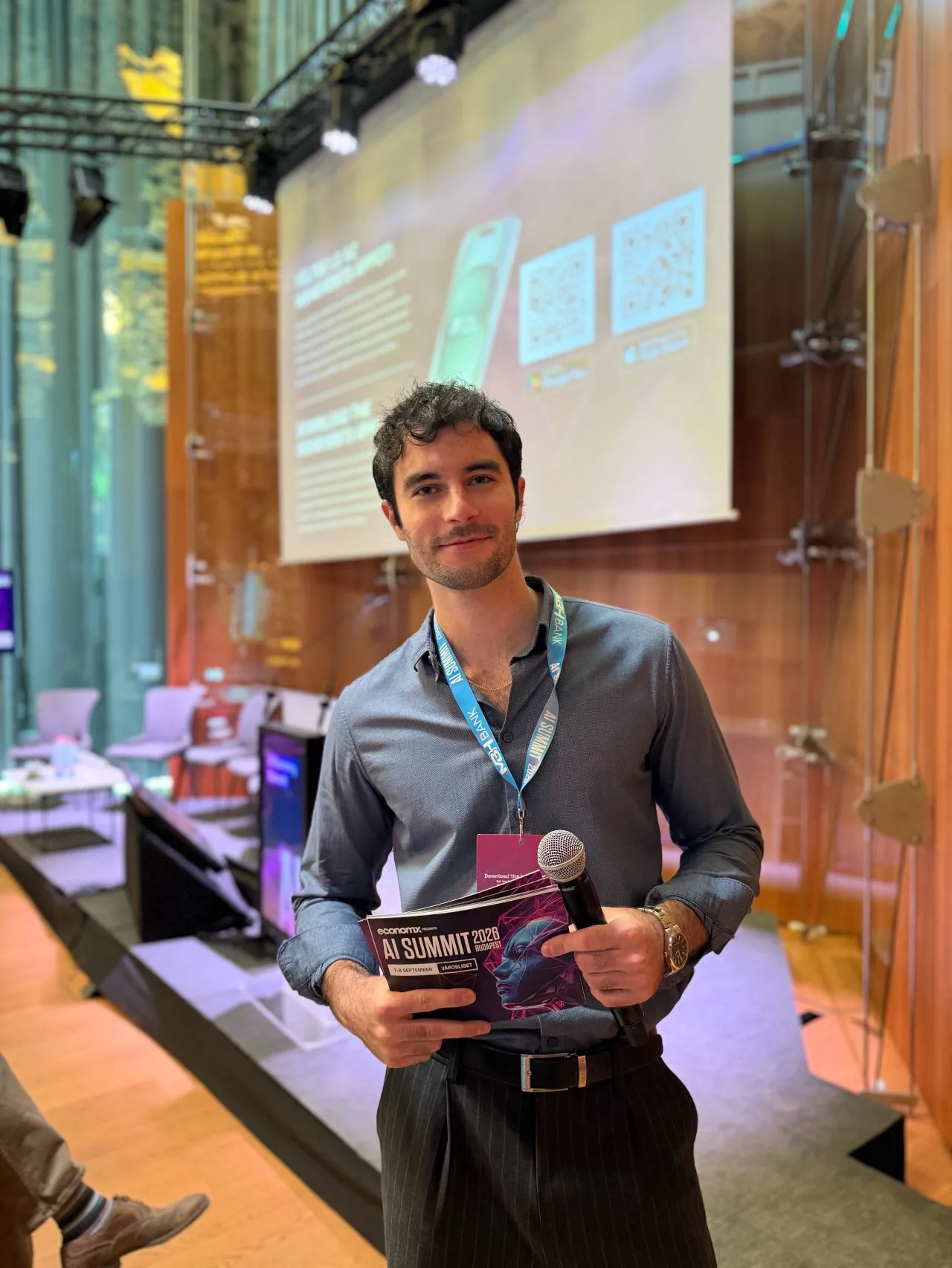 dr. Balázs Áron mikrofonnal az AI Summit Budapest színpada előtt